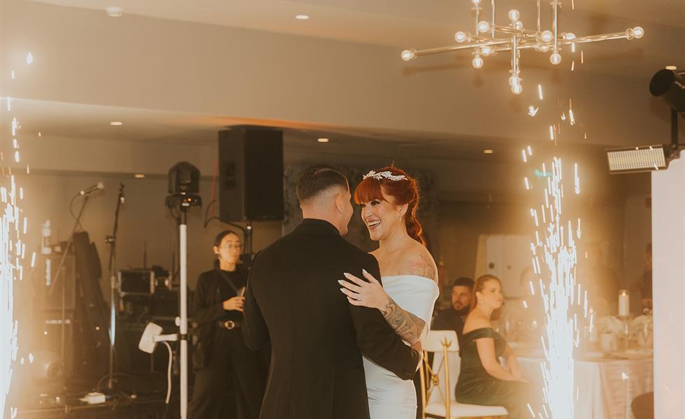 Patricia and David celebrating their wedding with fireworks going off behind them