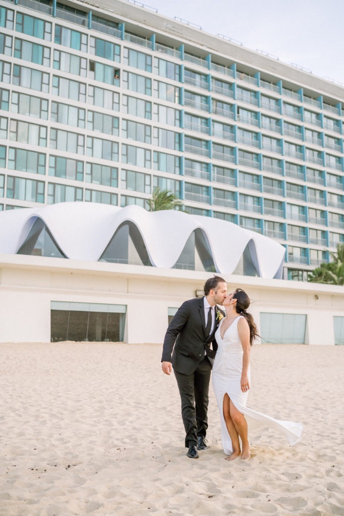 Bride and groom kissing on the beach