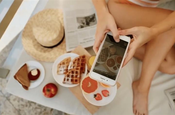 A woman taking photos of her food