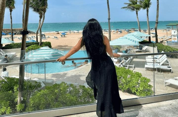 A woman on a terrace overlooking the beach