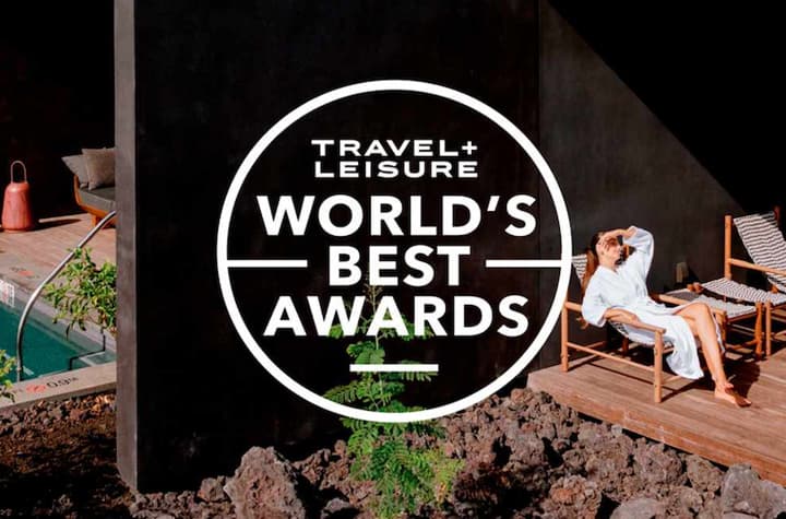 Travel and Leisure World's Best Awards Logo with a background that has a woman relaxing in a lounge chair by a small private pool