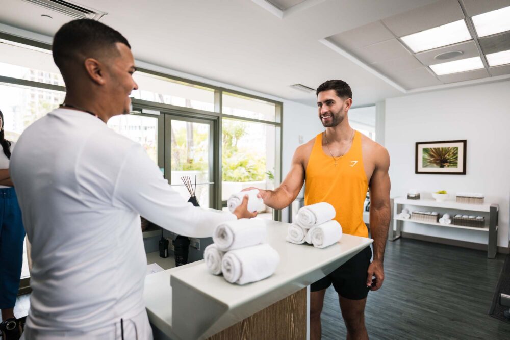 fitness center service at la concha - employee handing out towel to guest